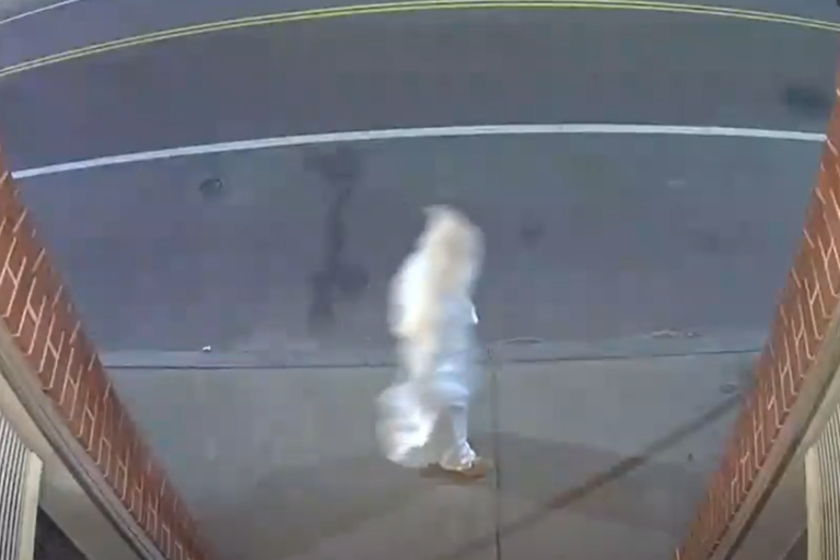 A screenshot of surveillance footage from Candy’s Curiosities & Vintage recorded on April 27 shows a person dressed in a white hood and robe walking on a sidewalk in West Warwick, Rhode Island.